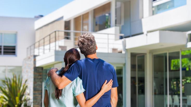 Salon lumineux visité par des acheteurs accompagnés de leur courtier immobilier